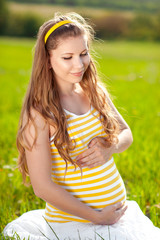 Naklejka na ściany i meble Smiling pregnant woman outdoors