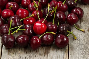 Ripe whole black cherries on rustic wood ready to eat