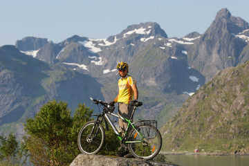 Naklejka na ściany i meble Biking in Norway against picturesque landscape