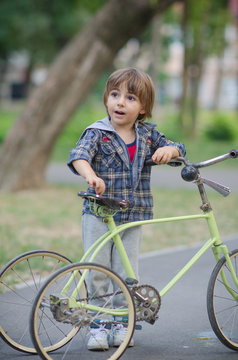 Happy boy with bicycle in the autumn park