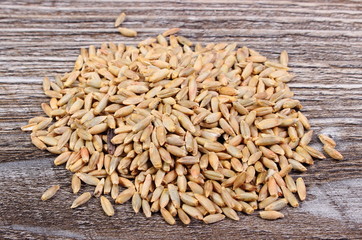 Heap of rye grain on wooden background