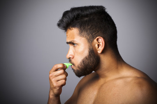 Joven latino con barba soplando pito