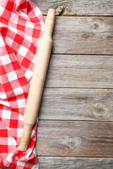 Empty wooden table with rolling pin and napkin on grey backgroun