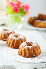 Bundt cakes on cutting board on white wooden background