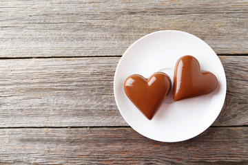 Chocolate heart on plate on grey wooden background