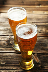 Two glass of beer on brown wooden background