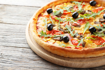 Fresh tasty pizza on grey wooden background