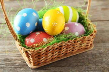 Easter eggs in basket on grey wooden background