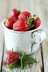 Strawberries berry in cup on grey wooden background