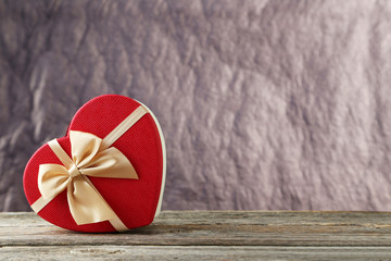 Beautiful heart gift box on grey wooden background