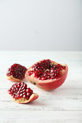 Delicious pomegranate fruit on white wooden background