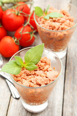 Glass with granita from fresh tomatoes on grey wooden background