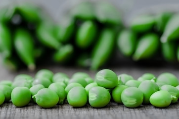 Green organic peas on wooden background, shalow focus