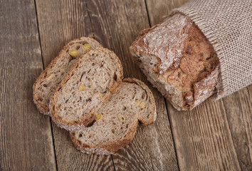 Sliced brown bread on wooden table. Top view.