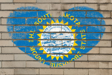 heart shape flag of south dakota on brick wall