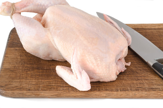 Raw chicken carcass on cutting board isolated on white