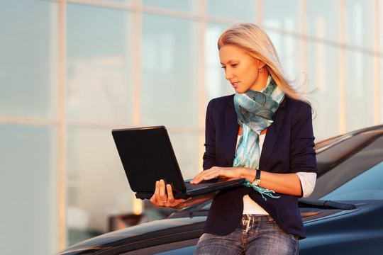 Young Fashion Business Woman With Laptop By Her Car