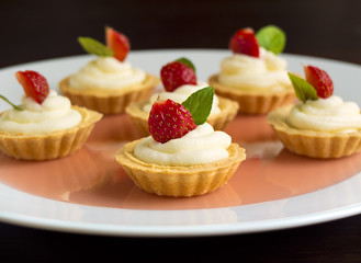 Tiny cupcakes with strawberry, whipped cream, jelly and mint