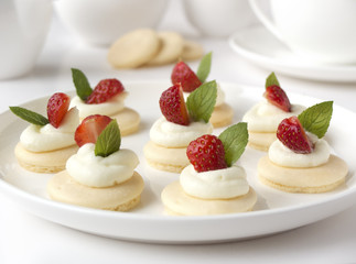 Small biscuits with whipped cream and strawberry