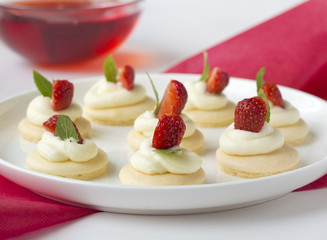 Small biscuits with whipped cream and strawberry