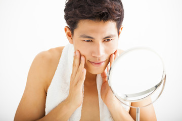 Young  man touching his smooth face after shaving