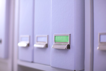 File folders, standing on  shelves in the background