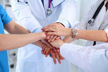 Doctors and nurses in a medical team stacking hands 