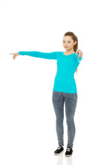 Young woman pointing on you and aside.