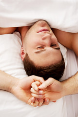 Fototapeta na wymiar Handsome young man lying in bed.