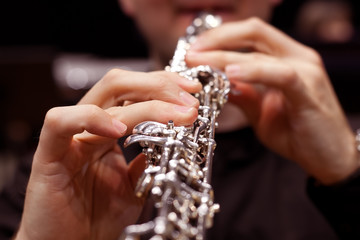 The fingers of the person playing the oboe closeup