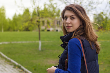 Obraz premium Portrait of a beautiful young woman walking on spring park.