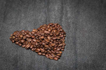 Coffee beans in the shape of a love heart on stone.