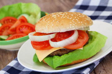 Cheeseburger and green salad, closeup
