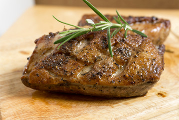 Fried duck breast with rosemary on board