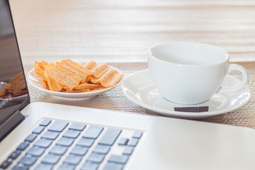 Laptop with coffee cup and snack