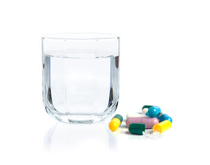 Drug capsules and drinking water on white background - 84250396