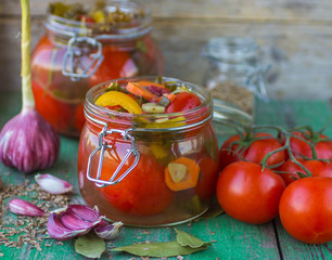 Open glass jar of tasty canned tomatoes