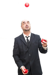 Businessman that is juggling with a red balls