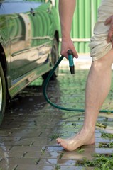 Men's feet, wash with a garden hose