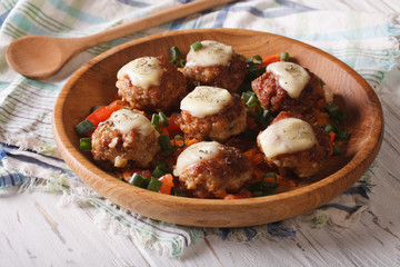 meat balls with cheese and vegetables in a wooden bowl