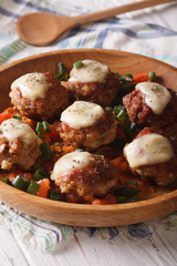 Baked meat balls with mozzarella  in a wooden bowl. Vertical
