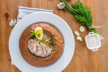 Traditional polish zurek with sausage, egg in bread