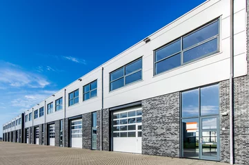 Foto op Plexiglas Industrieel gebouw modern industrieel gebouw met laaddeuren en blauwe lucht