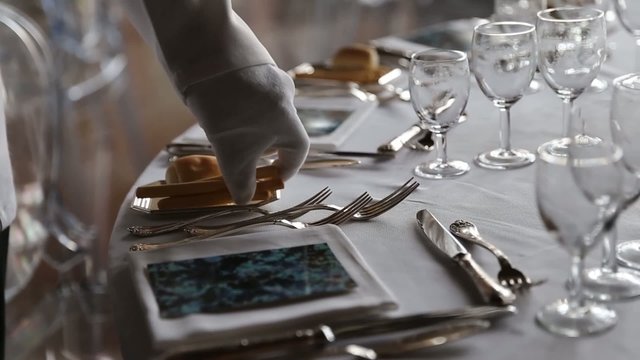 Waiter set the table for dinner in exclusive and luxury restaurant