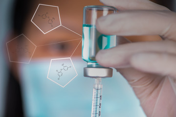 Closed up Nurse fills syringe from injection vial and chemical s