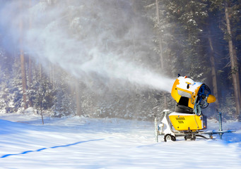 Snow gun on the background of the winter forest