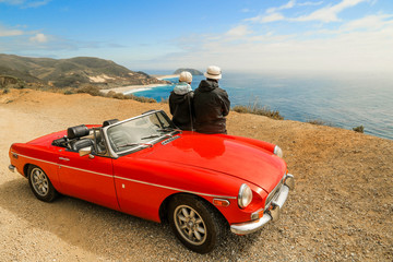 Roter Oldtimer mit älterem Paar auf Amerikas Traumstraße