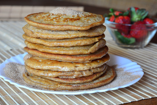 Stack of sweet pancakes with strawberries and cinnamon sugar 
