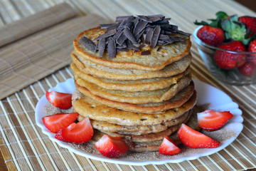 Stack of sweet pancakes with strawberries and chocolate