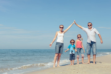 Happy family standing on the beach at the day time.